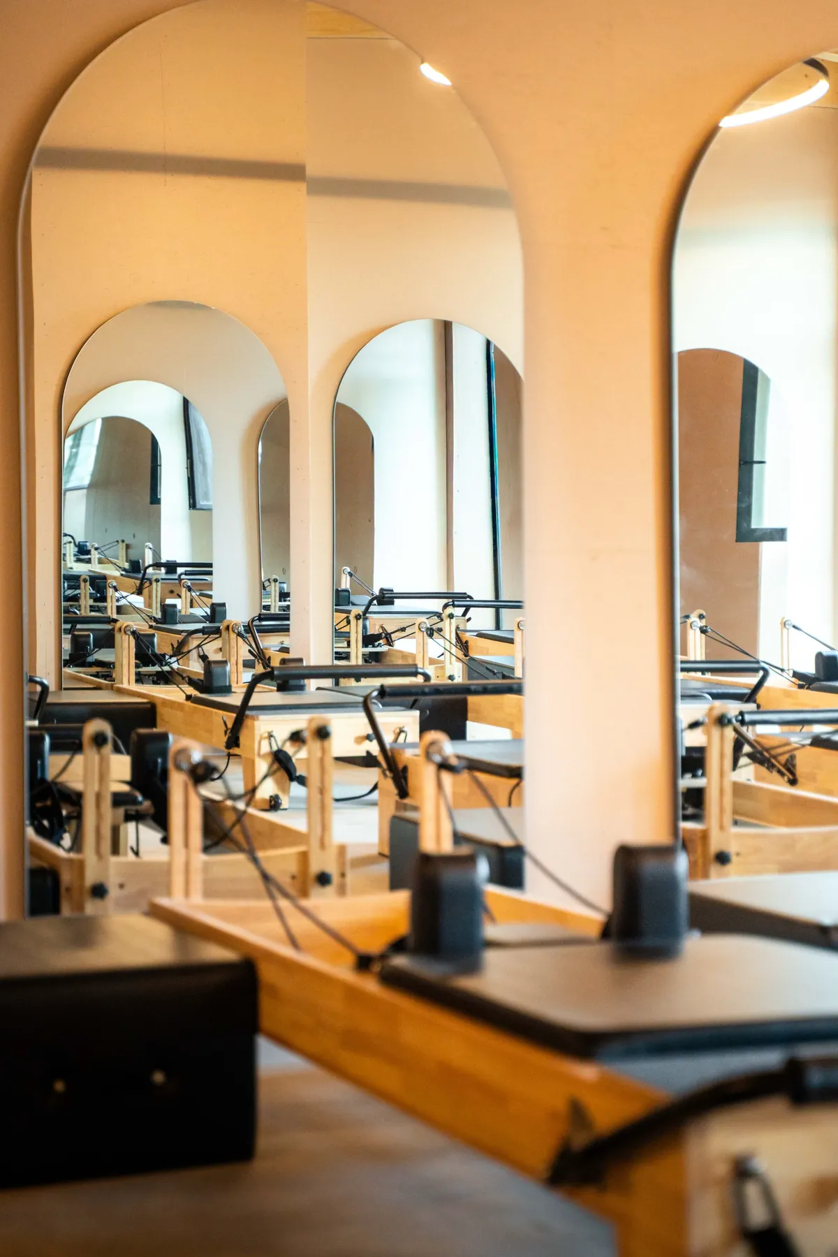 Studio de Pilates Reformer du Five.Club à Delémont, miroirs cintrés et machines en bois